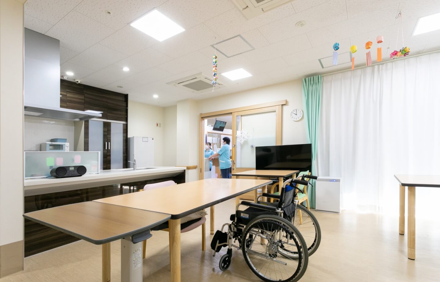 車椅子対応のキッチン付き共用スペース。明るく清潔な居住環境です。